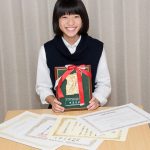 英語弁論大会での盾と賞状を手にする中学生の女の子