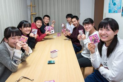 中学生の高松英会話の生徒たちがカードを持って笑っています。