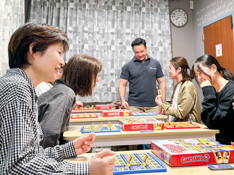 高松英会話ケビンズイングリッシュハウスで大人の生徒たちが英語のグループレッスン中にゲームを楽しみながら会話している写真
