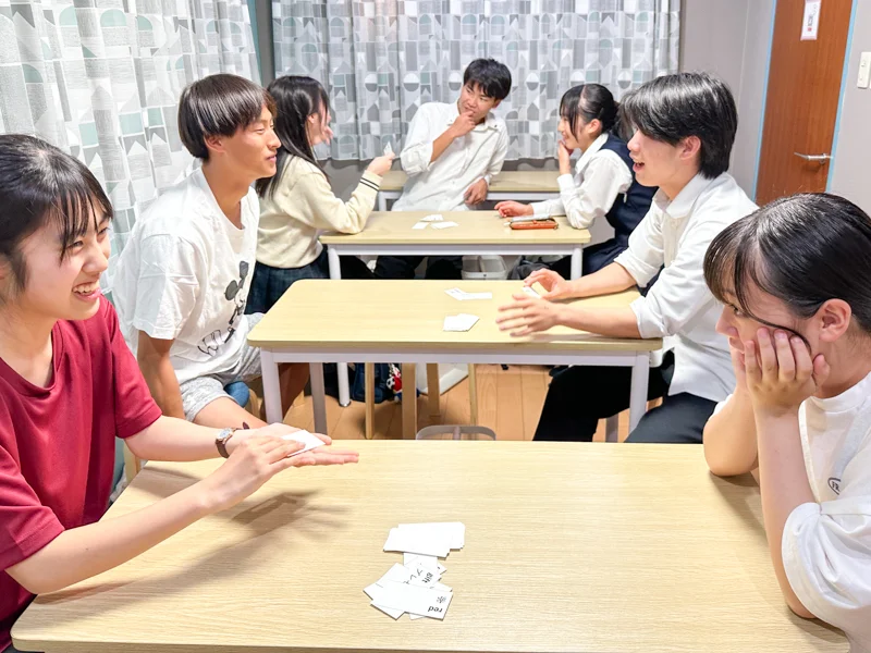高松英会話ケビンズイングリッシュハウスで高校生たちが英語のグループレッスン中にヒントゲームを楽しんでいる写真