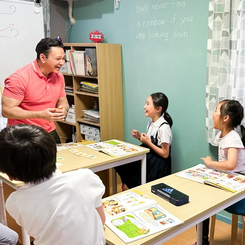 高松英会話ケビンズイングリッシュハウスでケビン先生が小学生の子どもたちに楽しく英語を教えている様子の写真